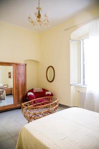 a bedroom with a bed and a chair and a window at Casa Terracotta in Matera +11 photos
