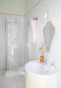a white bathroom with a sink and a shower at Casa Terracotta in Matera