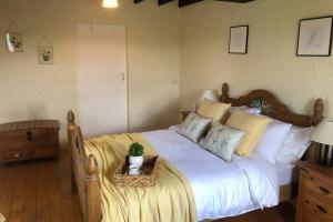 sypialnia z dużym łóżkiem z białą pościelą i poduszkami w obiekcie Clannad Cottage w mieście Arboe