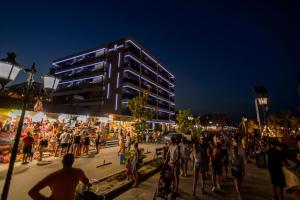 a crowd of people standing on a beach at night at Plazza Mamaia Nord in Mamaia Nord