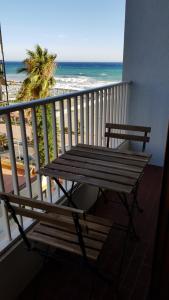 a wooden bench sitting on a balcony overlooking the beach at Casalmare Sabina in Ventimiglia