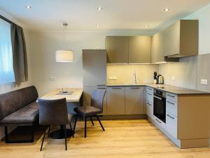 a kitchen with a table and chairs and a dining room at Hotel Garni Burger in Sankt Jakob in Defereggen