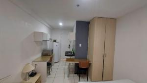 una cocina con armarios blancos y una mesa en una habitación en Flat Bellagio - suítes econômicas - Ferreira Hospedagens, en São Luís