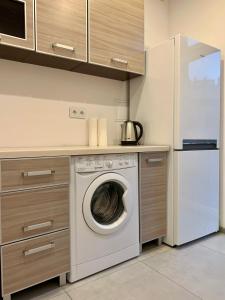 a kitchen with a washing machine and a refrigerator at Felicjanek Apartment in Krakow