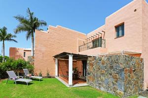 a house with a stone wall in the yard at Salobre Morro Golf 1 in Salobre