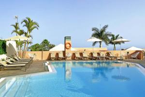 a large swimming pool with chairs and umbrellas at Salobre Morro Golf 1 in Salobre