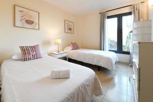 a hotel room with two beds and a window at Salobre Morro Golf 1 in Salobre
