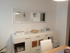 vestidor blanco en un comedor con espejo en Room Mina, en Rovinj