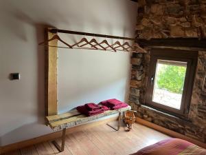 a bedroom with a mirror on the wall and a window at La Casuka, VUT-LE-1341 in Cofiñal