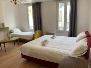 Habitación de hotel con 2 camas y mesa en Gîtes des châteaux : gîte C en Selles-sur-Cher