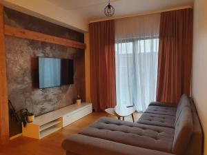 sala de estar con sofá y TV de pantalla plana en Cozy apartment in the heart of Pärnu en Pärnu