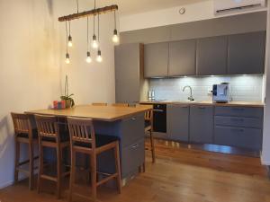 una cocina con una mesa de madera y una isla azul en Cozy apartment in the heart of Pärnu en Pärnu