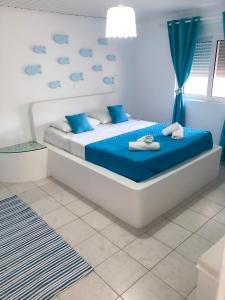a bedroom with a bed with blue sheets and clouds on the wall at Carpe Diem Studios in Ialysos