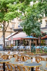 eine Gruppe von Tischen und Stühlen in einer Straße in der Unterkunft HolidaysInParis - Bourg Tibourg in Paris