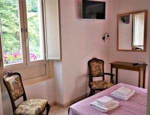 Habitación con mesa, 2 sillas y ventana en Hotel Baldo en Ferraro di Monte Baldo