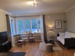 a living room with a couch and a large window at Lovely, spacious apartment with free parking in Sandviken