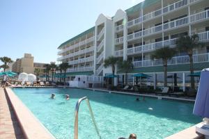 a swimming pool in front of a large building at Oceanview Studio in Daytona Beach