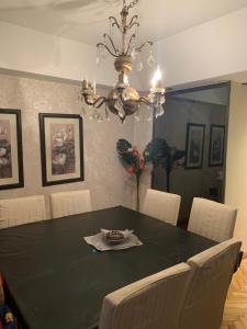 a dining room with a black table and a chandelier at Tagle-Recoleta in Buenos Aires +5 photos
