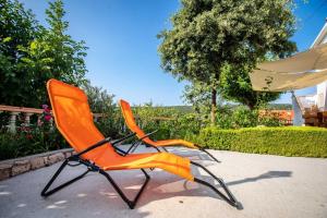 an orange chair sitting on the ground in a yard at Apartments Marija - good location in Supetarska Draga