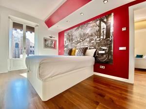 a bedroom with a white bed with a red wall at Charming Exclusive La Latina in Madrid