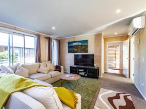 a living room with a couch and a tv at Family Retreat in Snowmass - Ohakune Holiday Home in Ohakune