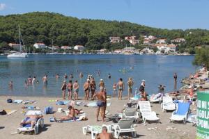 a group of people on a beach in the water at Apartments Mir - perfect location & cosy in Korčula