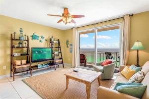 a living room with a couch and a tv and a balcony at Splash Condo, Aqua Park, Lazy River in Panama City Beach