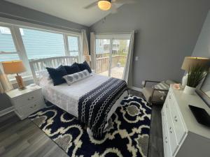 a bedroom with a bed and a large window at Dog Friendly Cottage just steps to beach / Outdoor living & dining room / Tons of Amenities / Book Now! in Gulf Shores