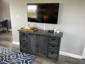 TV en la parte superior de un tocador de madera en una habitación en Dog Friendly Cottage just steps to beach / Outdoor living & dining room / Tons of Amenities / Book Now! en Gulf Shores