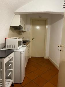 a small kitchen with a microwave on a counter at Casa do Menino Jesus in Évora