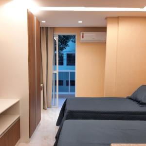 um quarto com uma cama e uma porta de vidro deslizante em Apartamento Mania em Vitória