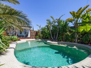 a swimming pool in a yard with palm trees at Como Palm Retreat in Rye