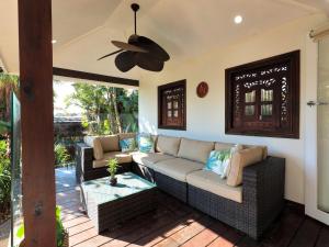 eine Terrasse mit einem Sofa und einem Tisch in der Unterkunft Como Palm Retreat in Rye