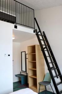 a room with a spiral staircase and a chair at Hotel Aurora in Nuuk