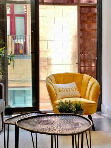 um sofá amarelo sentado ao lado de uma mesa de centro em Charming Malasaña Center em Madri