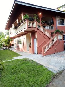 a house with a balcony with potted plants on it at 3 Bedroom Apartment in westerrn Tobago in Maryʼs Hill