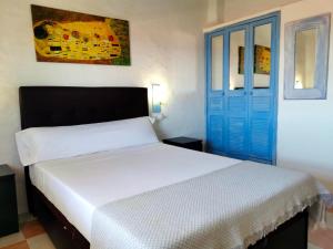 a bedroom with a bed and a blue door at La Perla De la Ostra in Platja de l’Almadrava