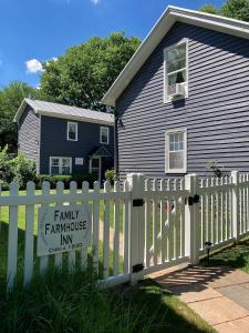 una casa con una valla con un cartel de posada familiar en Family Farmhouse Inn en Mount Jackson