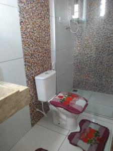 a bathroom with a toilet with a mosaic wall at pousada cangaço in São Gonçalo do Amarante
