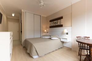 Un dormitorio con una cama y una mesa dentro. en Hotel Cavalinho Branco - Aptos 241 e 317, en Águas de Lindóia