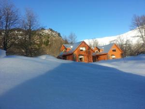 una casa con un montón de nieve delante de ella en Cabañas Maroni, en Las Trancas