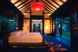 a bedroom with a bed and a red light at Banyan Tree Lijiang in Lijiang