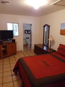 a bedroom with a bed and a flat screen tv at Stagecoach Suites in Wickenburg