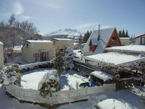 un patio cubierto de nieve con una casa en Ossies Motels and Chalets en Ohakune