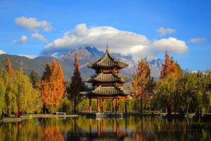 a pagoda in the middle of a lake with trees at Banyan Tree Lijiang in Lijiang