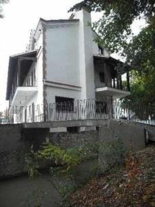 Dieses weiße Haus verfügt über eine Veranda und einen Balkon. in der Unterkunft Casa del Molino in Titulcia