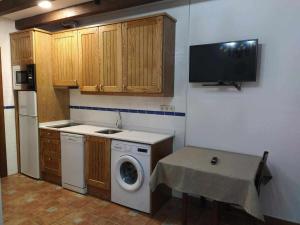 a kitchen with a washing machine and a tv on the wall at Casa del Molino in Titulcia