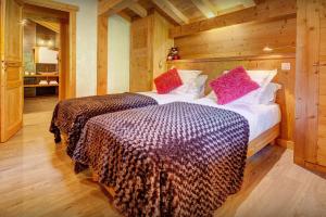 Les Villards-sur-ThônesにあるChalet Le Kitz - OVO Networkのベッド2台 木製の壁の部屋