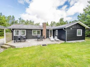 a log home with a deck and patio at Holiday home Nørre Nebel LXI in Nørre Nebel