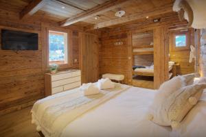 Les Villards-sur-ThônesにあるLa Ferme du Gran Shan - OVO Networkのログキャビン内のベッドルーム1室(大型ベッド1台付)